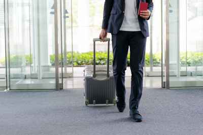 Mann mit Koffer am Flughafen